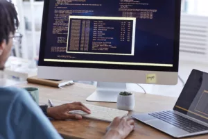 A person working on a computer with code and data on the screen, possibly engaging in software development.